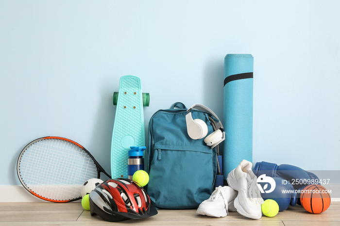 Set of sport equipment on floor near color wall