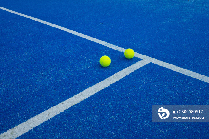 two balls in a blue paddle tennis court, racket sports concept