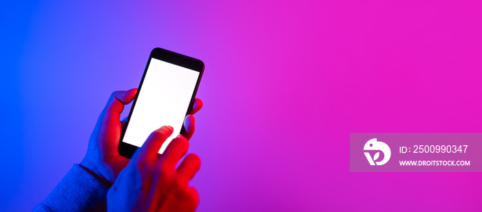 Male hands with smartphone. Blank white screen. Mock-up. Neon light