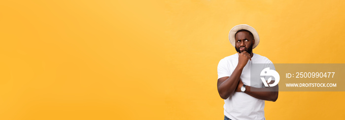 Human face expressions, emotions and feelings. Handsome young African American man looking up with thoughtful and skeptical expression, holding finger on his chin, trying to remember something.