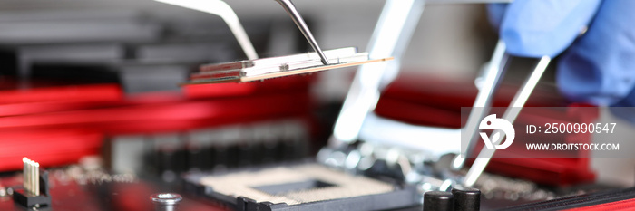 Close-up of workers hands repair computer. Man putting cpu on motherboard. Macro shot of intel microprocessor in the socket. Upgrade and technology concept