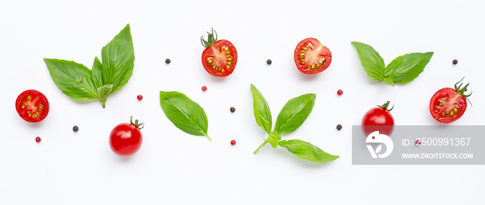 Fresh  cherry tomatoes with basil leaves and different type of peppercorns on white background. Top view