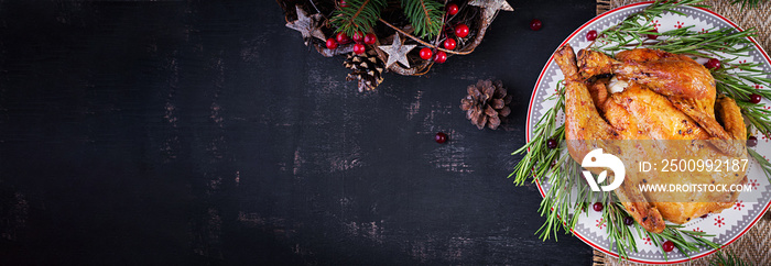 Baked  chicken or turkey. The Christmas table is served with turkey, decorated with bright tinsel. Fried chicken, table. Christmas dinner. Table setting. Top view, banner