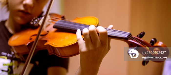 attentive young violinist plays music on the violin, horizontal