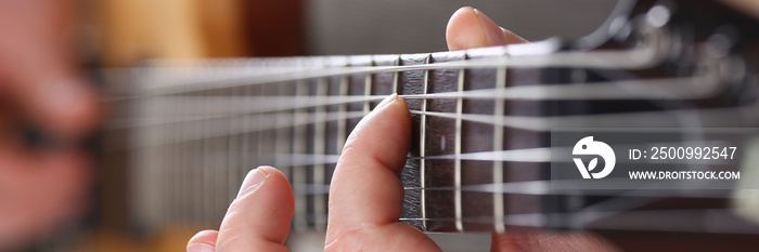 Male arms playing classic shape electric guitar