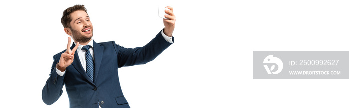 smiling businessman taking selfie and showing victory gesture isolated on white, banner