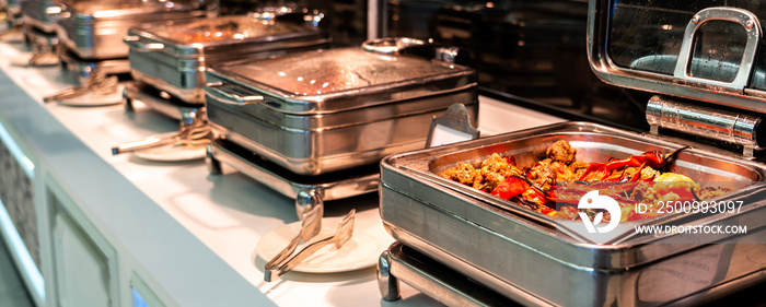 Breakfast and lunch buffet food catering banquet in hotel. Heated buffet container with meat and pepper