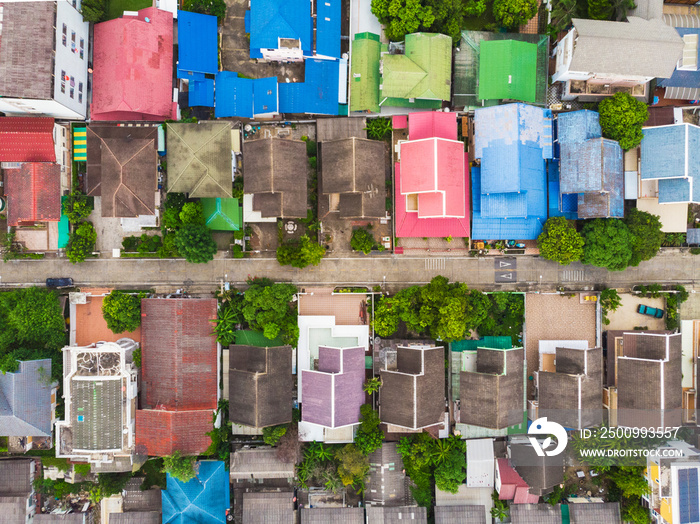 Aerial top-down view high altitude of slum a heavily populated urban informal settlement characterized by substandard housing and squalor poor living conditions streets and rusty metal home roof tops