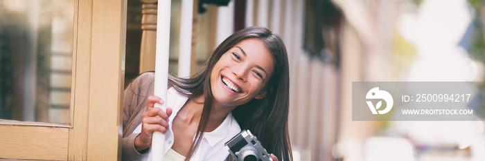 Smiling Asian woman taking pictures on Trolley street car ride with vintage camera panoramic banner. Tourist riding public transit tramway system in San Francisco.