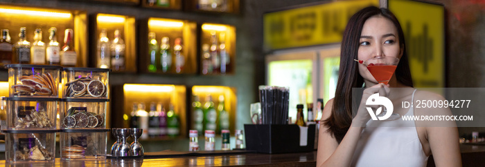 Asian alone women enjoy cocktails in front of a vintage bar, Relaxing activities after work or hangouts, Place of entertainment for young adolescents or night club party.