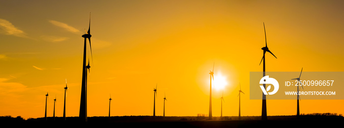 ein Panorama von vielen Windrädern bei Sonnenuntergang, im Sommer