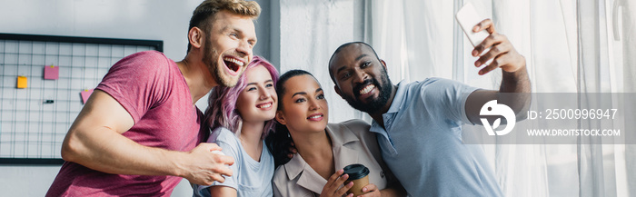 Horizontal image of multiethnic business people taking selfie with smartphone in white office