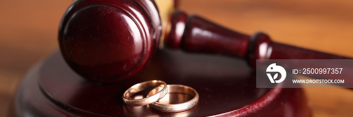 Closeup of judge hammer and wedding rings