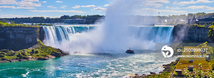 Eye level view of Niagara Falls Horseshoe Falls from Canada with mist surrounded tourist ship