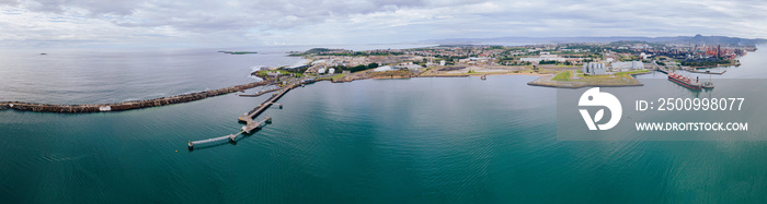 Aerial drone panoramic view of Port Kembla, in the Illawarra Region of NSW, showing the seaport, industrial complex and small harbour foreshore