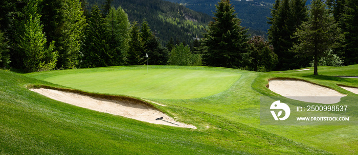 Fairway, sand traps, and green nestled into an alpine woodland, golf course background