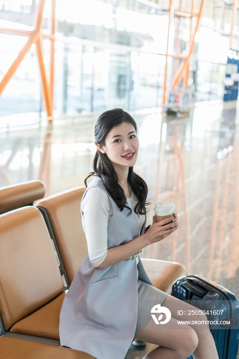 年轻商务女士在机场喝咖啡 