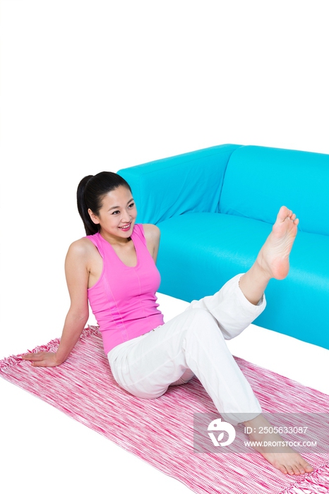 棚拍年轻女人坐在地毯上锻炼
