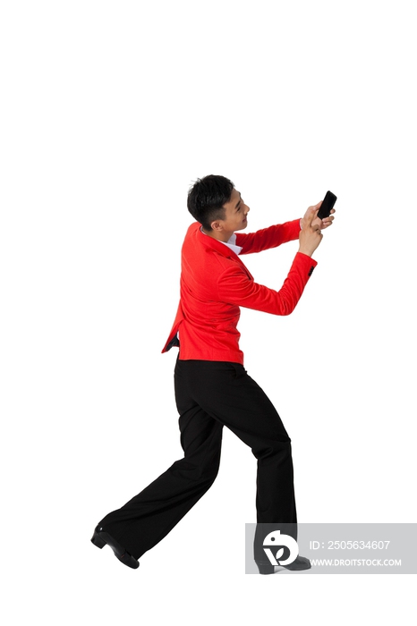 棚拍穿红色西装的年轻男人拿着手机跳舞