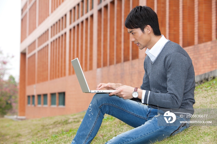 年轻大学生在校园里使用笔记本电脑