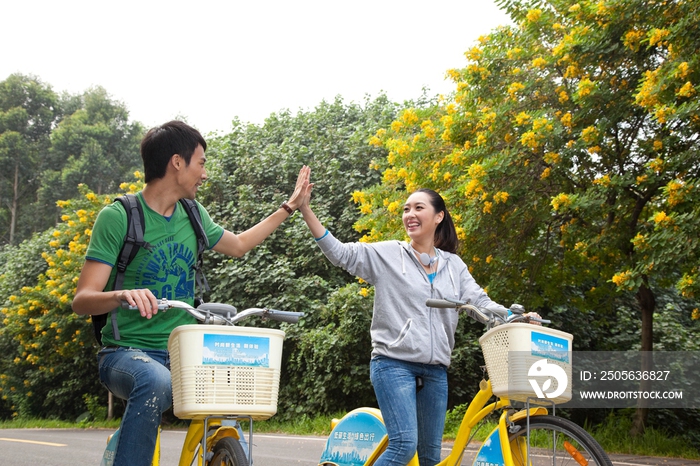 年轻大学生在校园里骑车