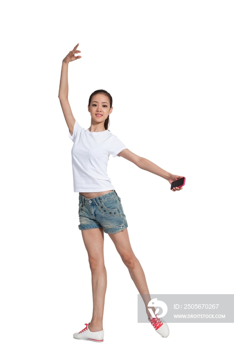 棚拍年轻女人拿着手机跳舞