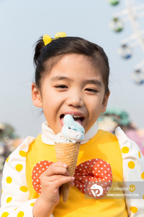 小女孩在游乐园吃冰淇淋