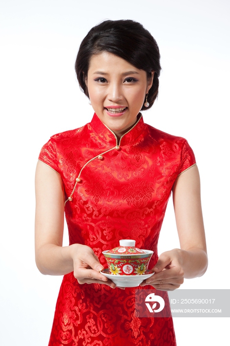 棚拍节日身穿红色旗袍的年轻女人端着茶杯