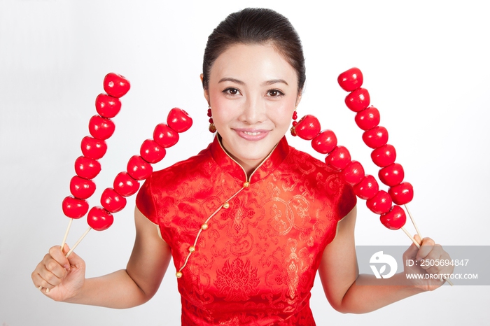 棚拍身穿中国传统服装的年轻女人和糖葫芦