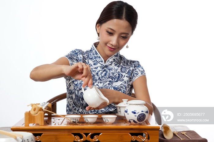 棚拍身穿中国传统服装的年轻女人秀茶艺