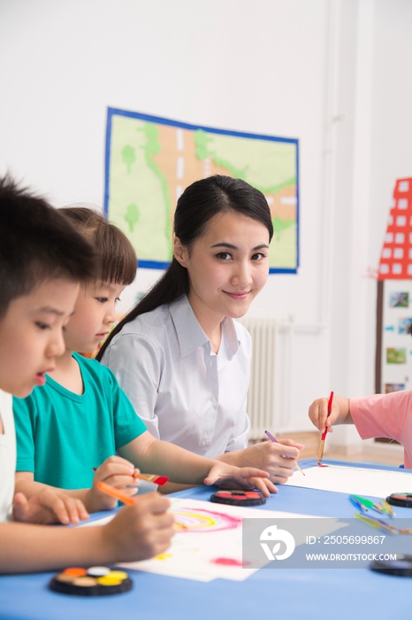 幼儿园女老师辅导儿童画画