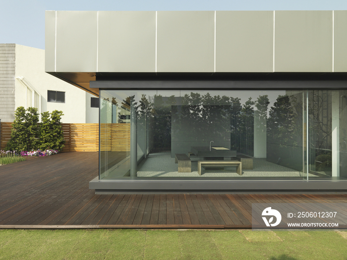 Exterior of modern office building with view of kitchen through glass wall