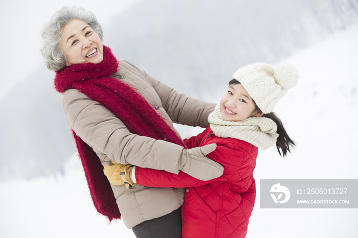 快乐的奶奶和孙女在雪地上拥抱