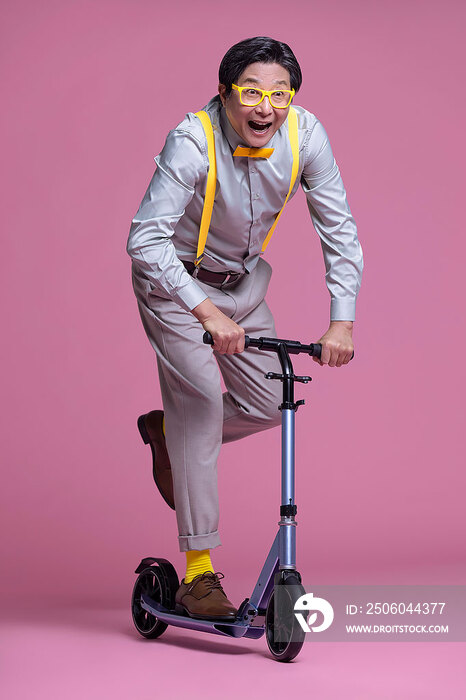 幽默时尚的老年男子骑滑板车