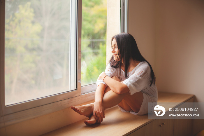 woman sitting on the window sill