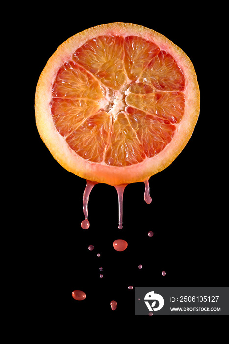 从刚切好的血橙中滴下的果汁