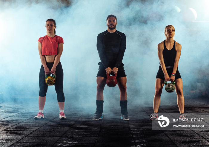 Young fitness people exercise with kettle bell