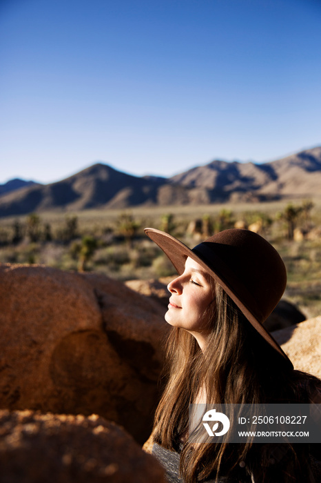 Young woman wearing hat in desert