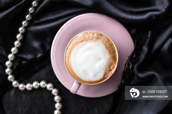 Cup of cappuccino for breakfast with satin and pearls jewellery background, organic coffee with lact