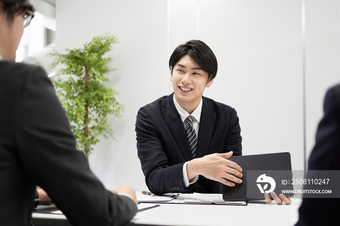 対面で説明する日本人男性ビジネスマン