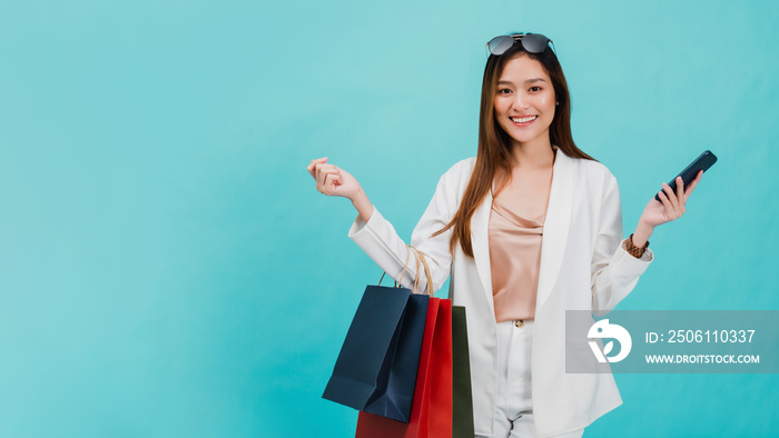 Asian beautiful women blogger are using the smartphone shopping online with a shopping bag in blue c