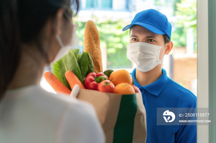 Asian delivery man wearing face mask and glove with groceries bag of food, fruit, vegetable give to 