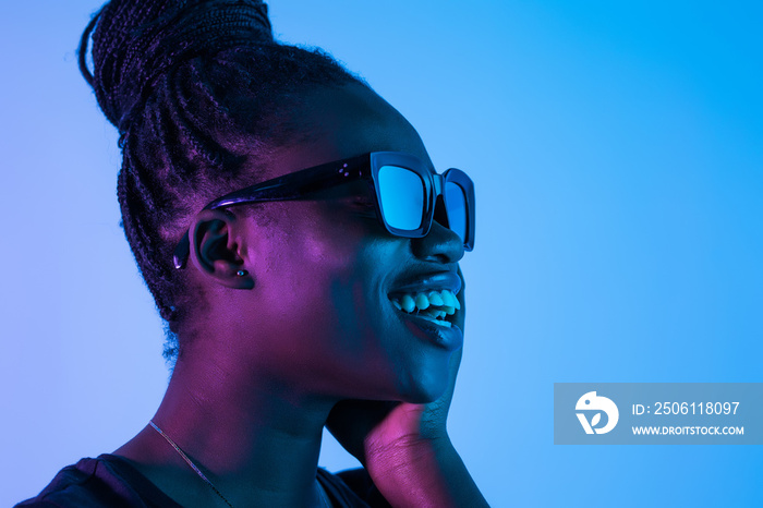 Fashion young african girl woman wear glasses looking at camera isolated on neon background