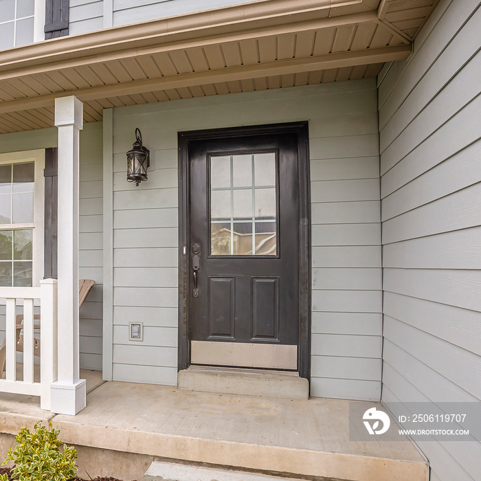 Square frame Exterior of home with glass panels on front door and stairs going to the porch