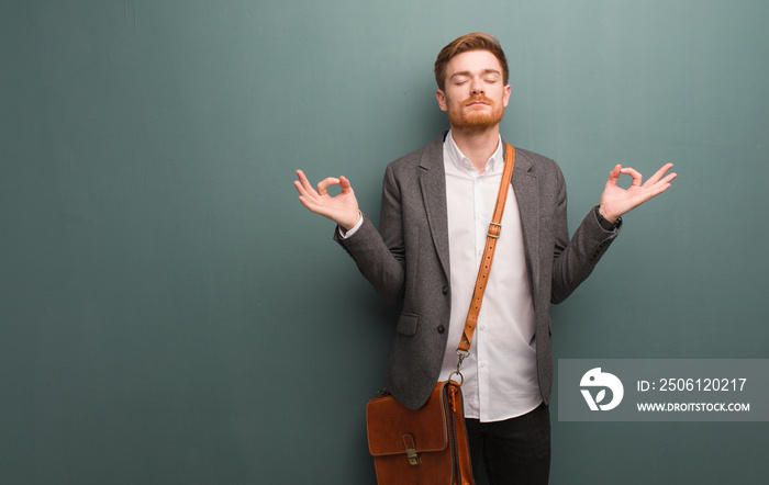 Young redhead business man performing yoga