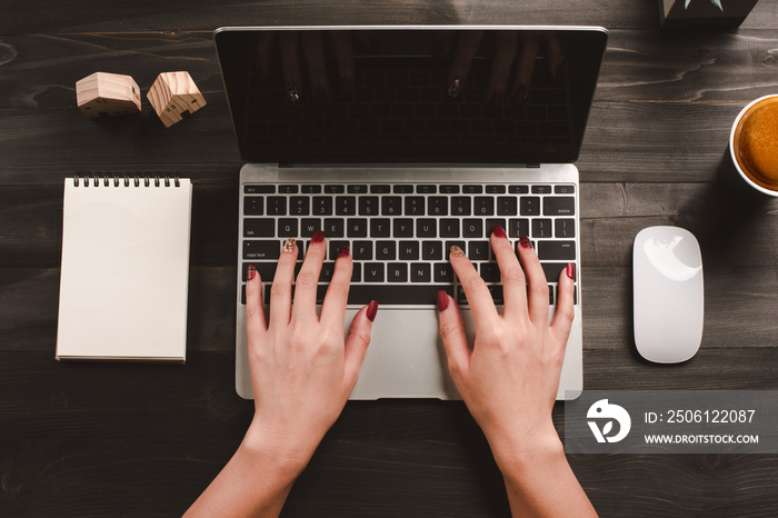 Woman working in home office hand on keyboard top view.