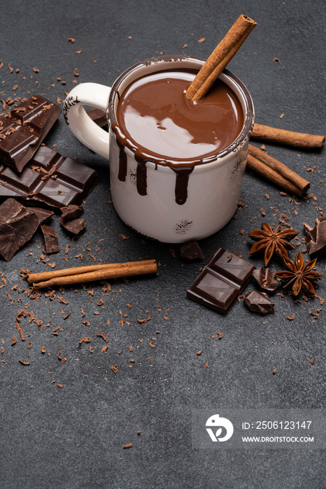 深色混凝土背景上的一杯热巧克力和几块巧克力