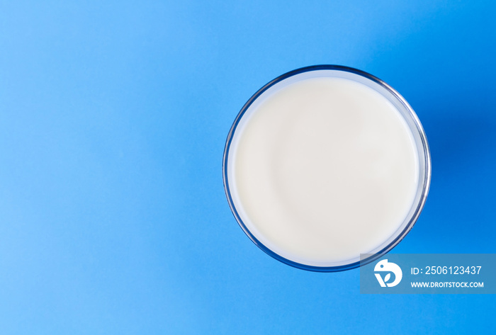 Closeup top view milk glass on blue background, healthy food concept