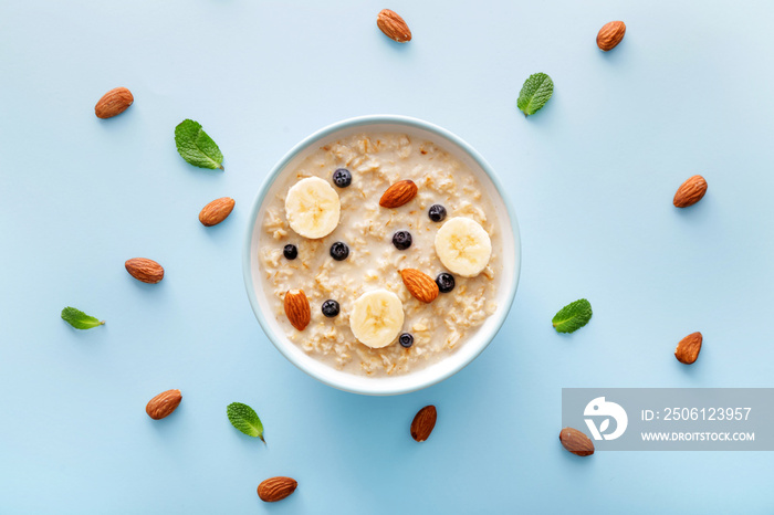 Bowl with tasty sweet oatmeal on color background