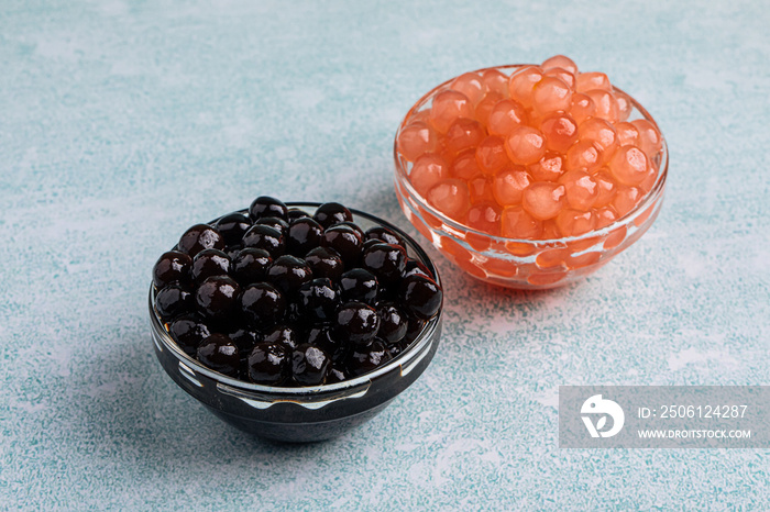 Two bowls of tapioca pearl bubbles on the blue background